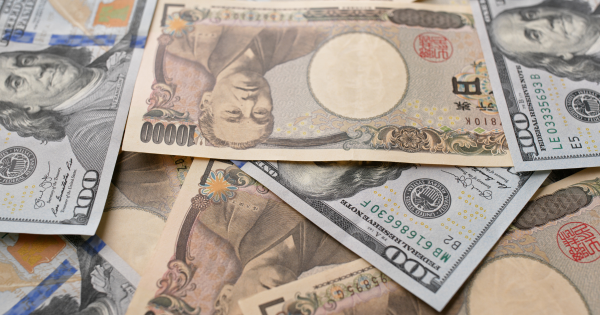 Close-up of 100 US Dollar bills mixed with 10,000 Japanese Yen notes.