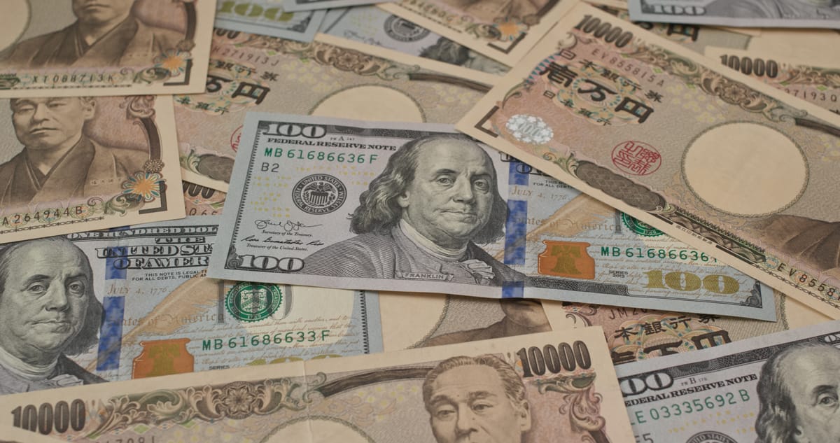 A scattered pile of Japanese 10,000 yen banknotes and United States 100 dollar bills overlapping each other.